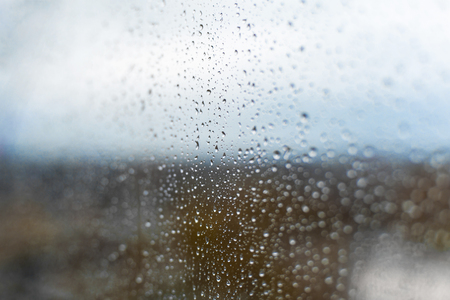 raindrops on the glass against the backdrop of the autumn city.の写真素材