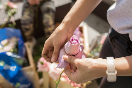 Closeup  florist girl prepares fresh flowers to decorate the event. Wedding florist arranges workflow.の写真素材