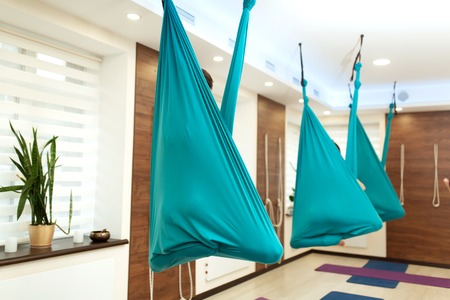 Women meditation in hammock. fly yoga stretching exercises in gym. Fit and wellness lifestyle.の写真素材