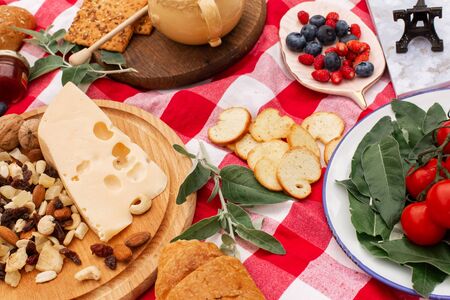 Stylish picnic on the green lawn. Fresh croissants and a teapot with tea on a bedspread near a...