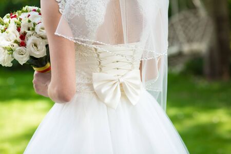 The girl in an elegant white wedding dress with bow at the back.の写真素材