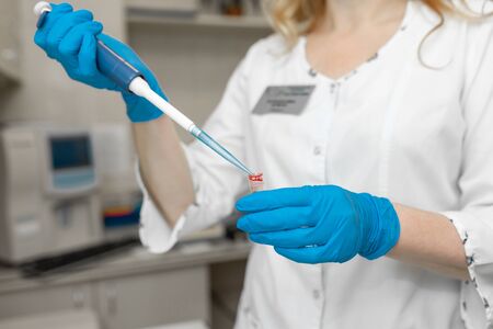 Woman lab technician take blood sample from test tube.