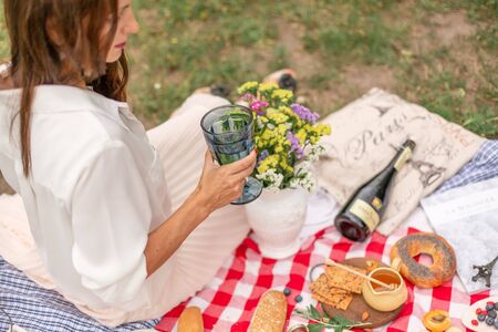 Young brunette woman enjoy outdoor picnic on green lawn