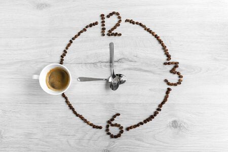 Coffee beans folded in the form of a clock. Instead of the number 9, a cup of coffee, which means it's time to drink coffee.の写真素材