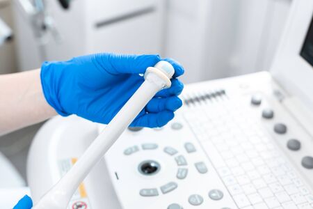 gynecologist puts a condom on the ultrasound sensor to examine the internal organs of the patient's pelvis.の写真素材