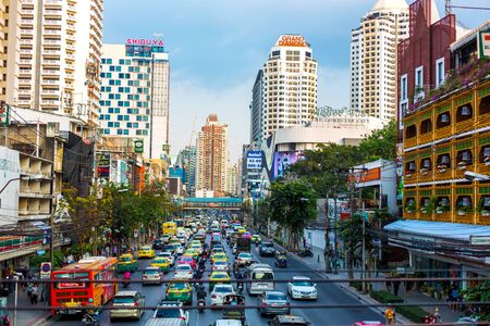 The streets of Bangkok. A wide street with multi-lane traffic and heavy traffic against skyscrapers.のeditorial素材