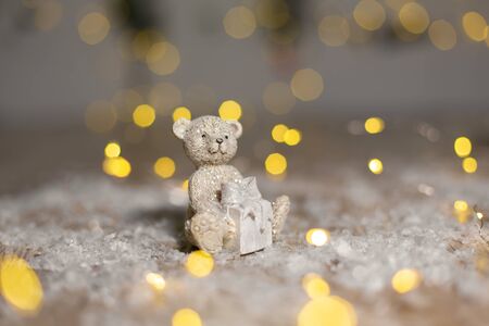 Decorative figurines of a Christmas theme. Statuette of a teddy bear with a scarf, sit next to the...