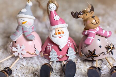 Decorative figurines of a Christmas theme. Set of statuettes of santa, snowman and deer. Christmas tree decoration. Festive decor, warm bokeh lightsの写真素材