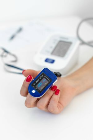 doctor puts a heart rate monitor on a patients finger.