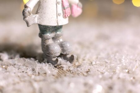 Decorative Christmas-themed figurines. Statuette of a man on skates. Christmas tree decoration. Festive decor, warm bokeh lightsの写真素材