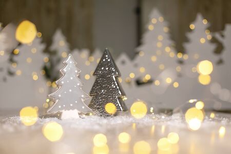 Decorative figurines of a Christmas theme. Statuette of a Christmas tree. Christmas tree decoration. Festive decor, warm bokeh lightsの写真素材