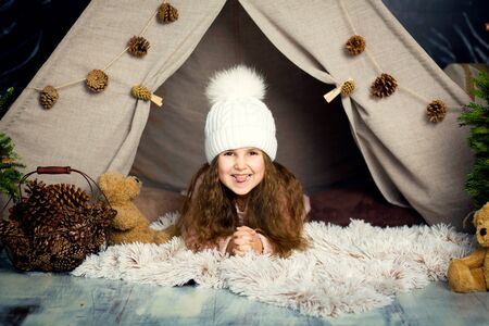 Merry Christmas and happy holidays. Happy childhood. Young girl lie on pillow in christmas...