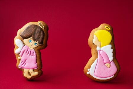 gingerbread cookie of little cute angels on red background. Traditional Christmas food. Christmas...