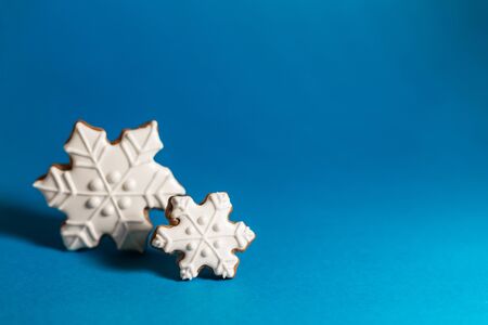gingerbread cookie of snowflake on blue background. Traditional Christmas food. Christmas and New...