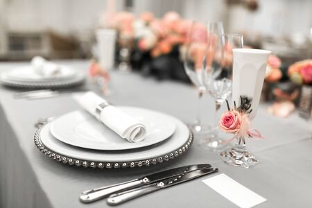 Part of stylish table setting with plate and cutlery. Nearby lies a white business card. Copy space.の写真素材
