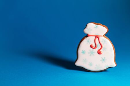 gingerbread cookie of Santa's bag on blue background. Traditional Christmas food. Christmas and New Year holiday concept. Copyspace.の写真素材