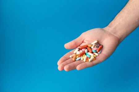 A handful of colored pills on the palm. Medical concept. Shopping at the pharmacy