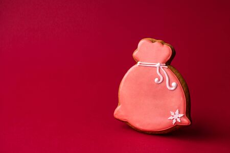gingerbread cookie closed santa claus red bag on red background. Traditional Christmas food. Christmas and New Year holiday conceptの写真素材