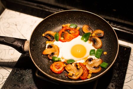 Freshly fried eggs with vegetables in a pan.の写真素材