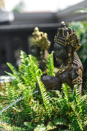 Balinese statuette of a girl with a pot from which water flows. Pool decoration.