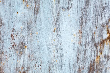 texture of an old rusty sheet of metal painted with white paint burnt out in the sun.