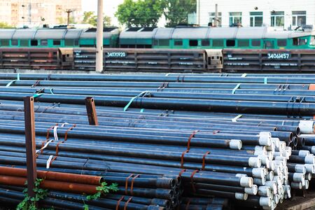 Metal rolling. Pipes folded in a railway warehouse are being prepared for shipment. The concept of...