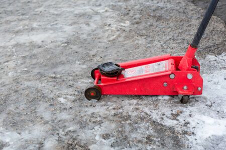 Red jack on tire service in winterの写真素材