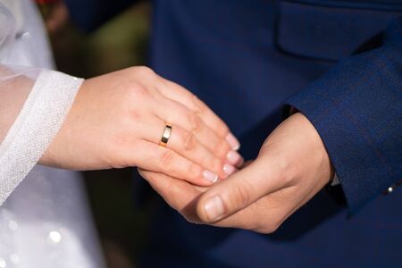 Groom holds the hand of his bride.の写真素材