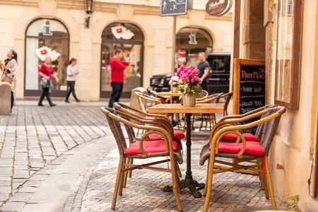 The architecture of the old city of Prague. Wooden furniture on the street near the cafe. romantic atmosphere.の写真素材