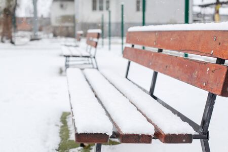 Benches for rest are covered with snow in the park in winterの写真素材