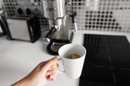 First-person view of a girl preparing delicious aromatic coffee in a coffee machine. A simple way to make coffee.の写真素材