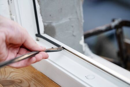 Professional master at repair and installation of windows, changes rubber seal gasket in pvc windows.の写真素材