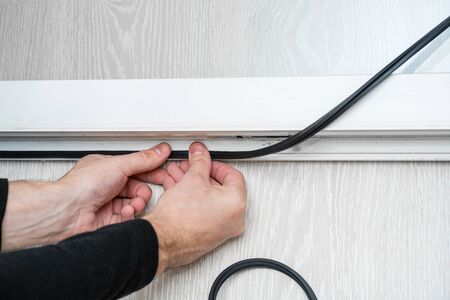 Professional master at repair and installation of windows, changes rubber seal gasket in pvc windows.の写真素材