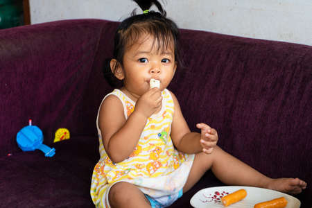 Little Thai girl eat carrot. Vitamins and proper nutrition for children.