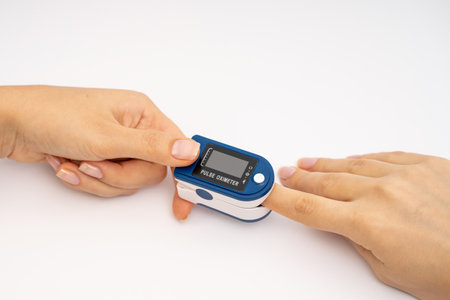 Fingertip Pulse Oximeter on finger. On white background. Device for self health diagnostic.