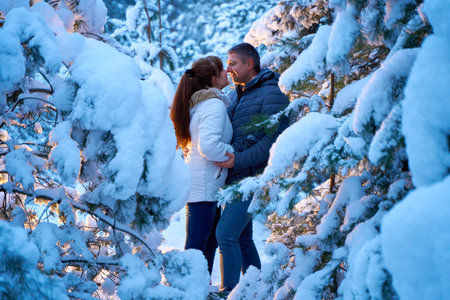 A joyful couple in love walking in winter forest heavy covered with snow.の写真素材