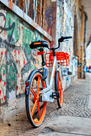 Stylish urban transport bright bicycle parked against a graffiti-painted wall. Berlin, Germany - 05.17.2019のeditorial素材