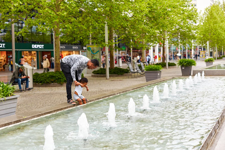 A father plays with his little daughter in the city fountain. Dresden, Germany - 05.20.2019のeditorial素材