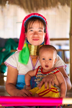 woman from the long-necked tribe, known for the metal rings worn around their necks, holding her child. Photo captures the bond between mother and child and celebrates cultural diversity and tradition. Chiang Rai, Thailand - 02/09/2022のeditorial素材