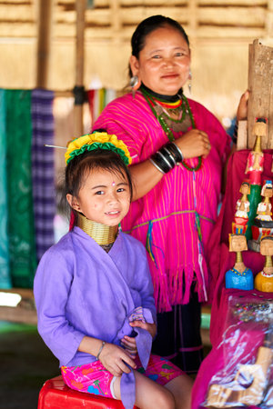 woman from the long-necked tribe, known for the metal rings worn around their necks, holding her...