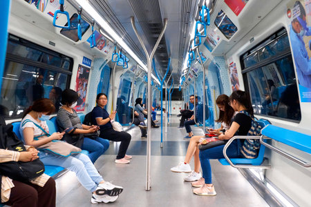 The interior of a modern subway car. New beautiful wagon. People in the subway go on business. Kuala Lumpur, Malaysia - 10/03/2020のeditorial素材