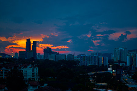 sunset with dark rainy clouds over modern city.の写真素材
