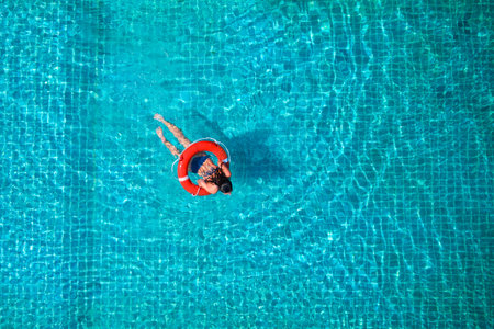 Lifeguard girl training with a life preserver swimming in the pool.の写真素材