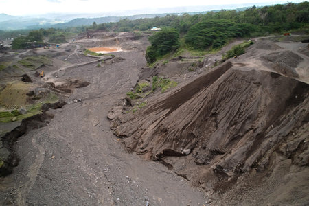A stone quarry in Indonesia. Large equipment such as bulldozers and dump trucks are working on the siteの写真素材