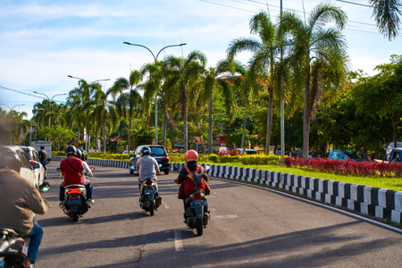 Asphalt roads and traffic with cars and motorcycles on the island of Bali. A cozy way through Asian villages. Bali, Indonesia - 11.30.2022のeditorial素材