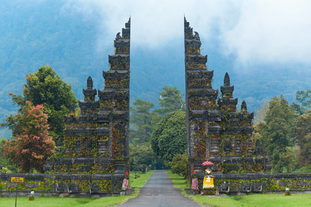 Balinese traditional gate against the background of mountains with clouds on the popular tourist island of Baliの写真素材