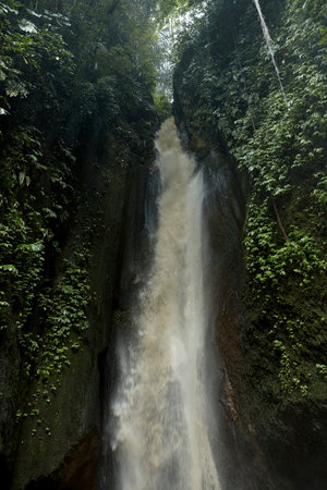 An incredibly beautiful waterfall in a cracked rock in the jungle on the popular island of Baliの写真素材