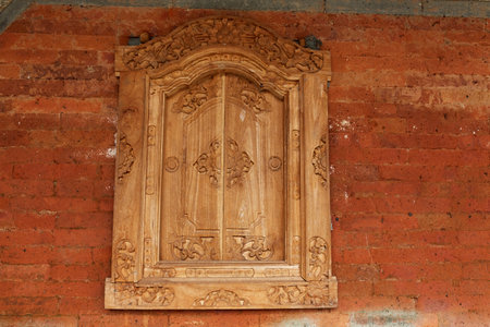 Homemade wooden sashes on a window in a traditional Balinese houseの写真素材
