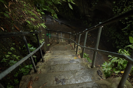 Moss-covered stairs lead to a mountain crevice with a waterfall in the jungle on the popular tourist island of Baliの写真素材