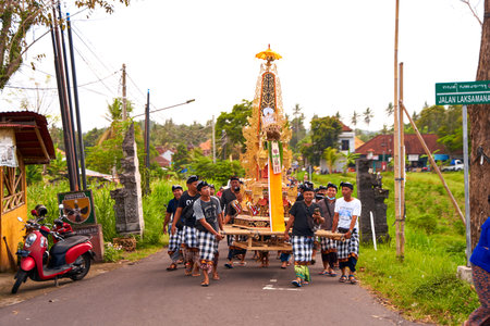 A funeral ceremony on the island of Bali. People in traditional colorful outfits put on jewelry and...